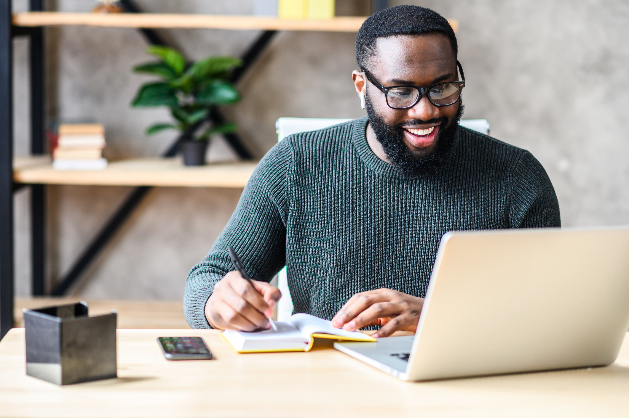 black man eagerly does work on laptop 